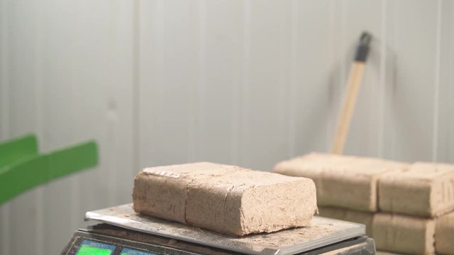 A close-up demonstration of manufactured wooden briquettes shape, size and weight