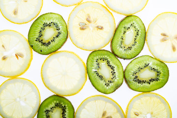 Background with lemon and kiwi. Slices of juicy lemon and kiwi top view
