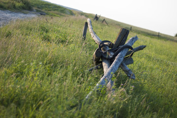 An old wood fence with a green country field behind it.