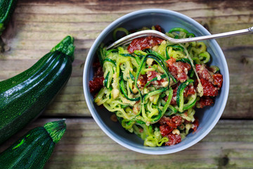Courgette spaghetti with sun dried tomatoes and mince hazelnuts - obrazy, fototapety, plakaty