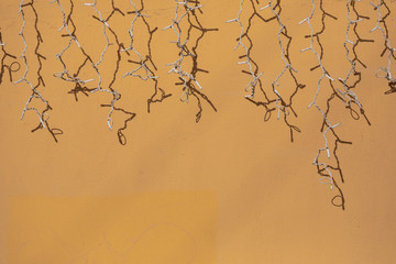 White garland on the background of the yellow wall on a sunny day