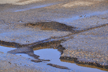 Potholes in roadway creating dangerous driving.