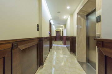 Long hotel corridor with marble floor