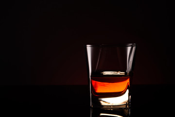 glass with alcoholic drink on a glass surface