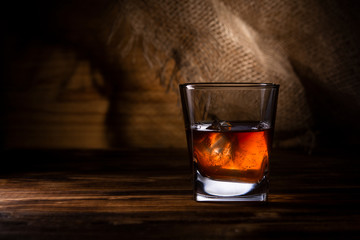 glass of whiskey or cognac on a wooden background