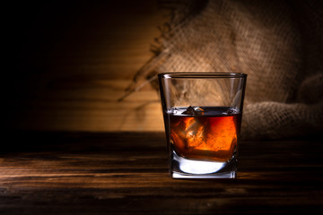 glass of whiskey or cognac on a wooden background