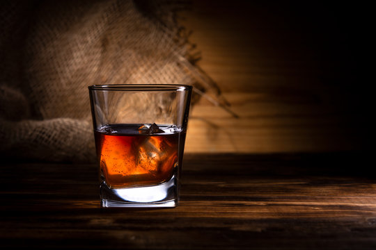 glass of whiskey or cognac on a wooden background