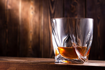 glass of whiskey or cognac over wooden background
