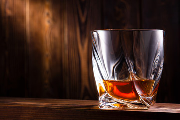 glass of whiskey or cognac on a wooden background