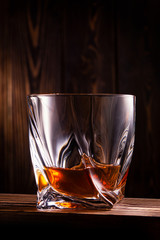glass of whiskey or cognac on a wooden background