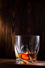 glass of whiskey or cognac over wooden background
