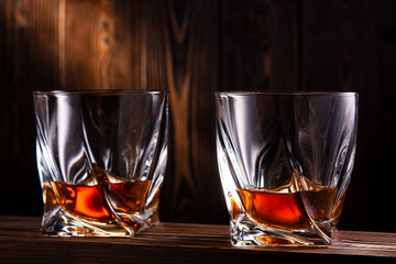 two glasses of whiskey over wooden background