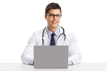 Male doctor sitting with a laptop and smiling