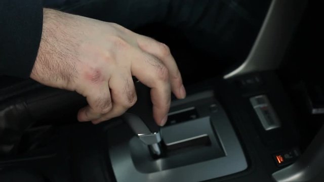 The driver puts the automatic transmission in the drive position, close-up
