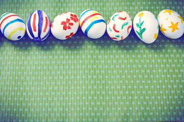 Painted Easter eggs on a green background with white polka dots. Toned image. Beautiful holiday card. Space for text. Happy easter.
