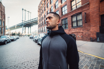 Motivated athlete man is ready for sport workout in New York City street