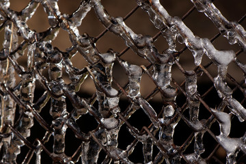 on a rusty mesh netting after freezing rain sleet. through the ice visible mesh