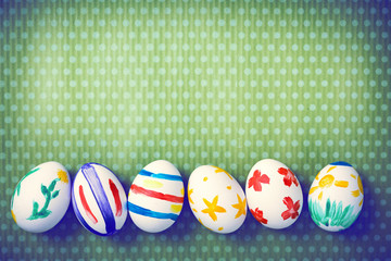 Painted Easter eggs on a green background with white polka dots. Toned image. Beautiful holiday card. Space for text. Happy easter.