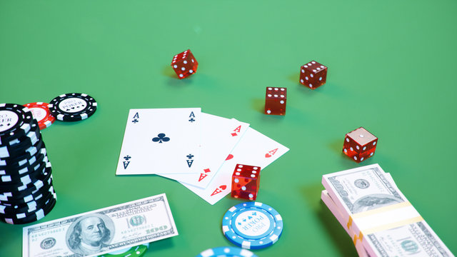 3D illustration casino game. Chips, playing cards for poker. Poker chips, red dice and money on green table. Online casino concept