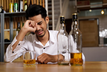 A man sitting at the pub is crying due to his sadness and want to forget it by drinking alcohol. He...