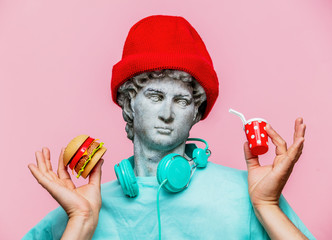 Antique bust of male in hat with cola drink and hamburger