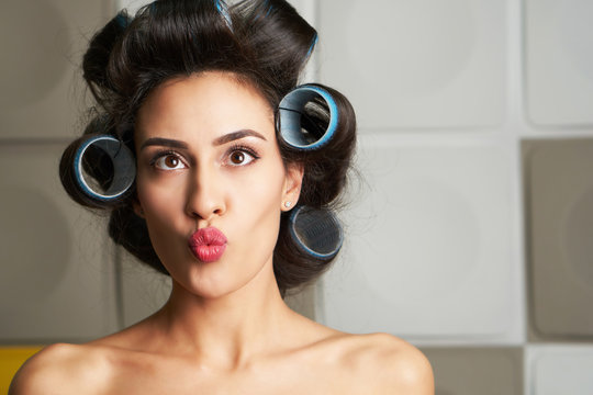 cheerful girl in hair curlers on her head