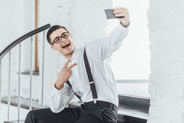 Successful businessman with his phone make a selfie in office.