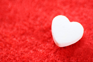 Obraz premium The heart is white on a red background. Heart medication. Love the concept. Close up.