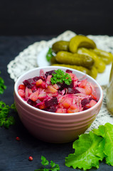 Russian salad vinaigrette next to greens, proper nutrition, vegetarian