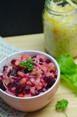 Russian salad vinaigrette next to greens, proper nutrition, vegetarian