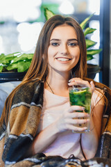 Young beautiful girl on a summer terrace is drinking cocktail.