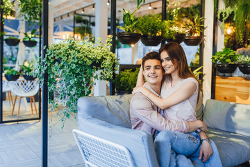 The guy and the girl are hugging in the cafe.