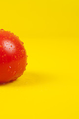 Fresh red tomato isolated on yellow background.