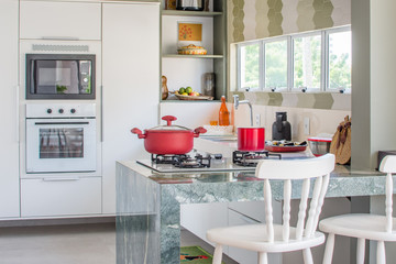 Cozinha moderna iluminada com panelas coloridas