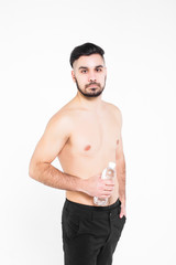 Fototapeta premium Portrait of tired young ,sports man, holding bottle of water, over white background .