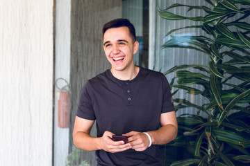 Midsection of a man using smart-phone texting message mobile phone smiling sms