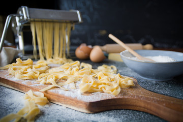 Still life homemade pasta. Pasta maker, eggshells, flour on a dark table. horizontal