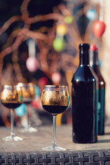 Bottle of vine, glass and easter eggs in blurry background. Spring easter concept.