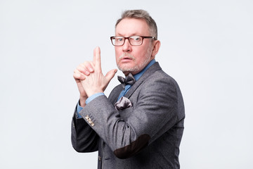 Senior man pretending he is holding gun