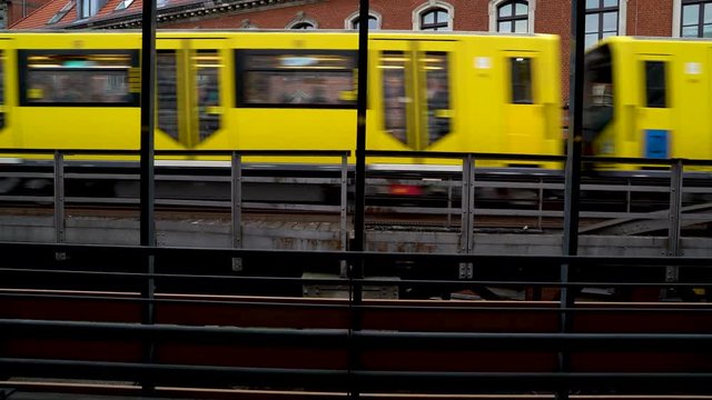 Image of a yellow tram passing in front of brick building, Berlin, Germany.
