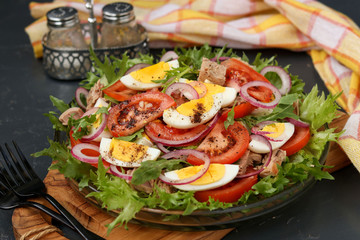 Healthy salad of organic salad with canned tuna, tomatoes, chicken eggs and red onion.