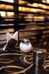 Sugar and chocolate cans for coffee in modern cafe, copy space with napkins