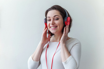 Energy young brunette lady woman listening music in headphones and singing isolated on white...