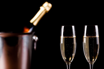 glasses of champagne on black  background with bokeh circles. Place for text.