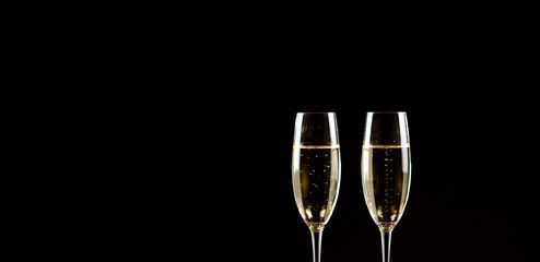 Champagne glasses on black background. Holiday celebration concept.
