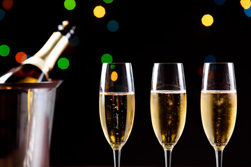 glasses of champagne on black  background with bokeh circles. Place for text.
