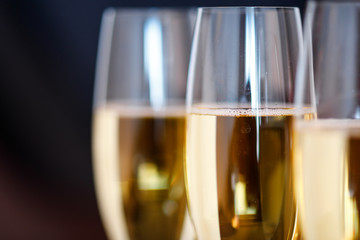 glasses of champagne on black  background with bokeh circles. Place for text.