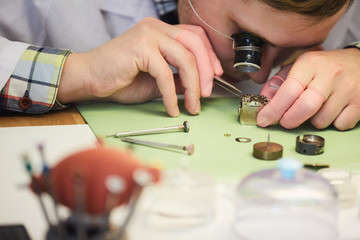 Close up of unrecognizable man repairing mechanical watch, copy space