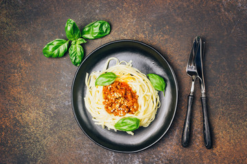 tagliatelle pasta with bolognese sauce and parmesan cheese in black plate
