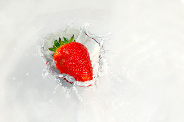bright red juicy strawberries falling into the water with splashes